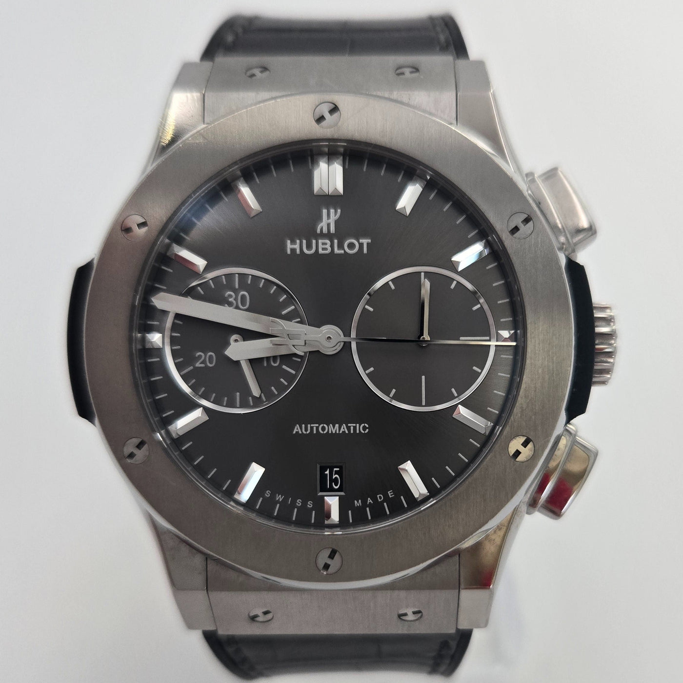 Hublot watch with black face and silver case on a white background