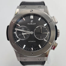 Hublot watch with black face and silver case on a white background