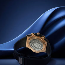Luxury watch with black strap and gold case on blue fabric background