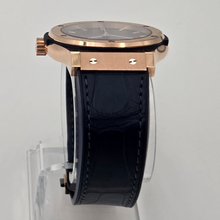 Hublot classic blue fusion watch with rose gold case and black leather strap on a gray background