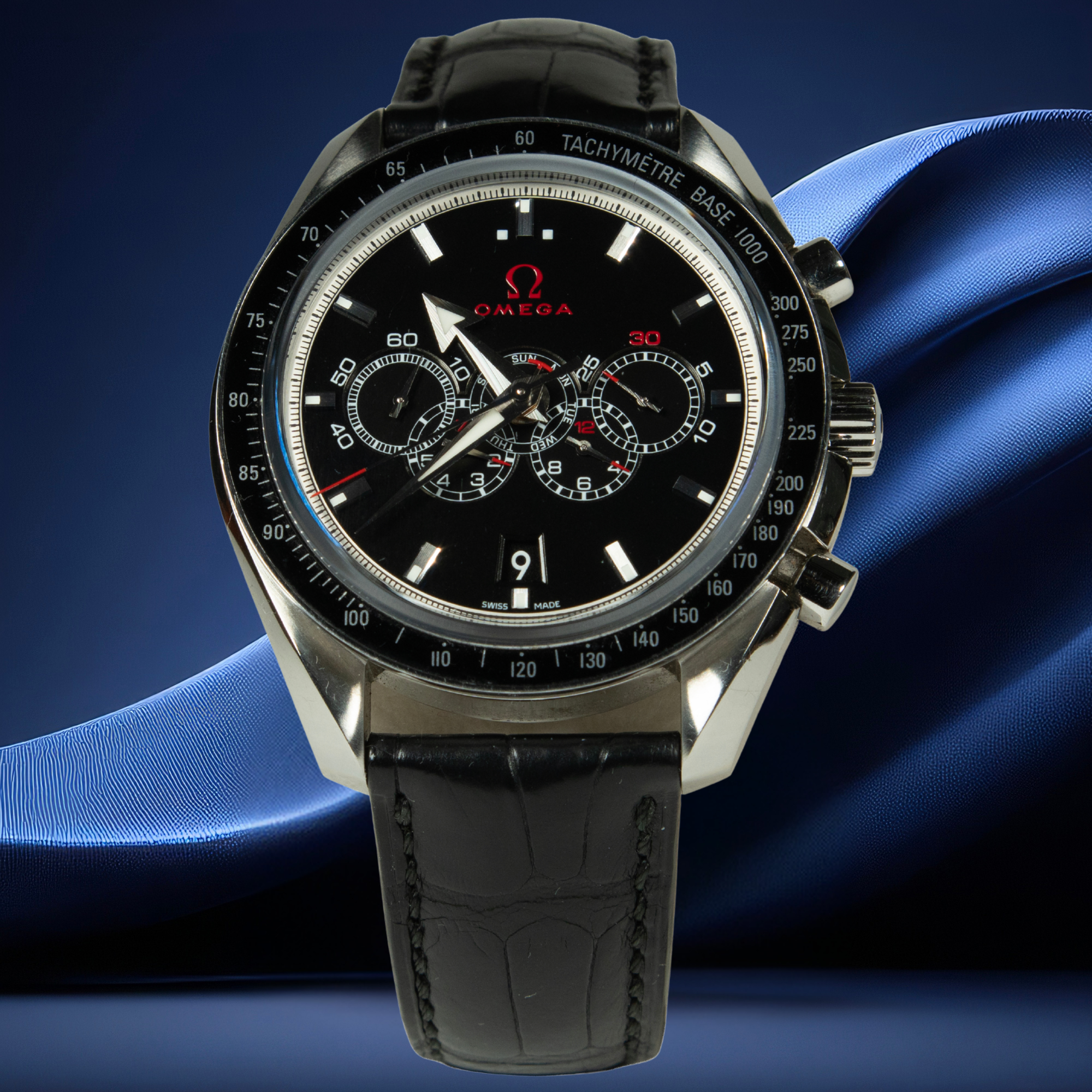 Omega watch with black dial and leather strap on a blue background