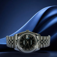 Silver watch with black dial on blue fabric