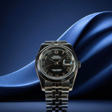 Rolex watch with black dial on a blue fabric background