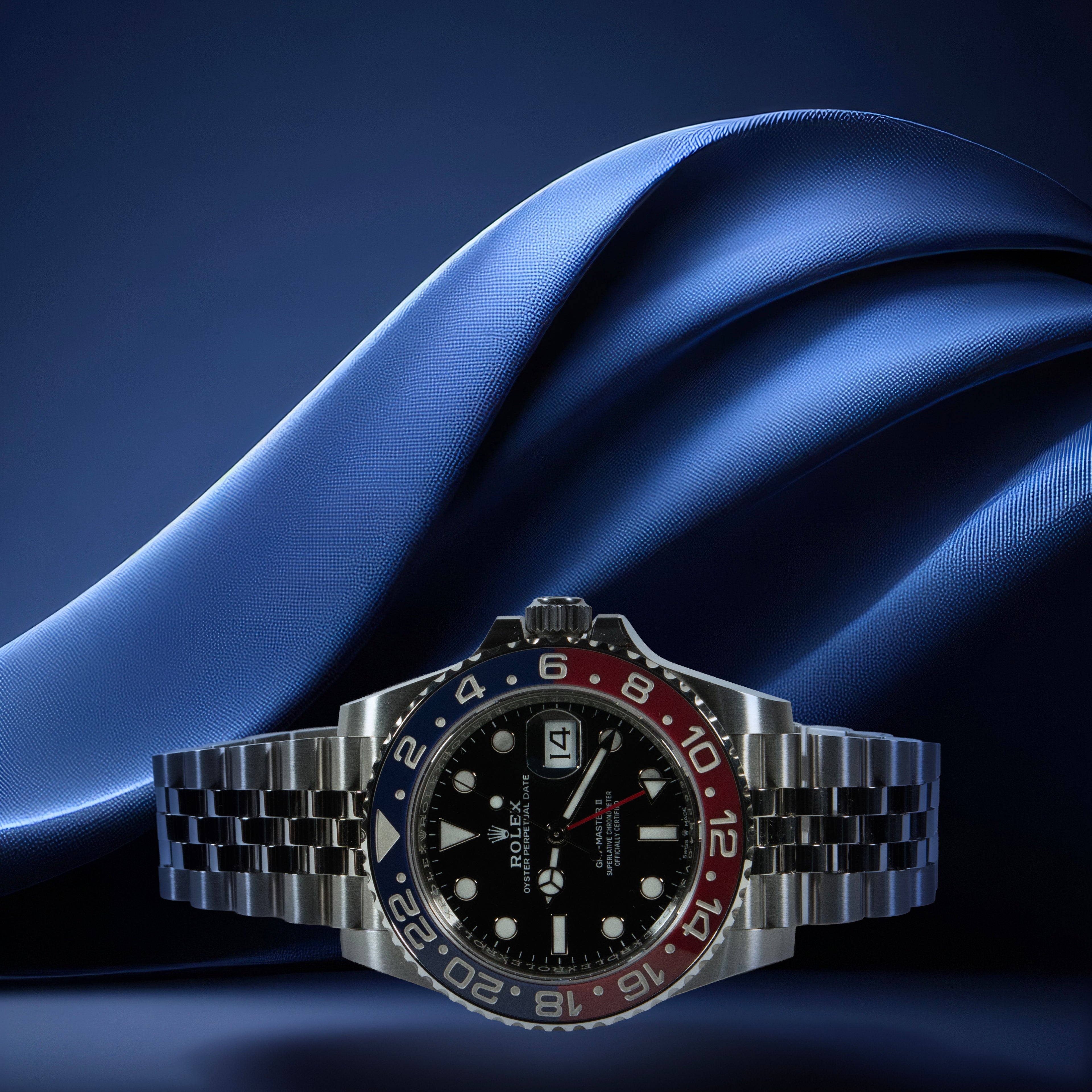 Rolex GMT Master II Pepsi with a red and blue bezel on a blue fabric background