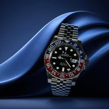 Rolex watch with a distinctive face and colorful bezel on a blue fabric background