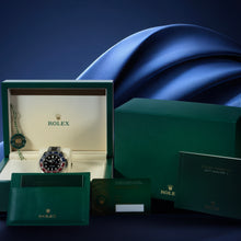 Rolex GMT Master II Pepsi with original box and papers on blue background.