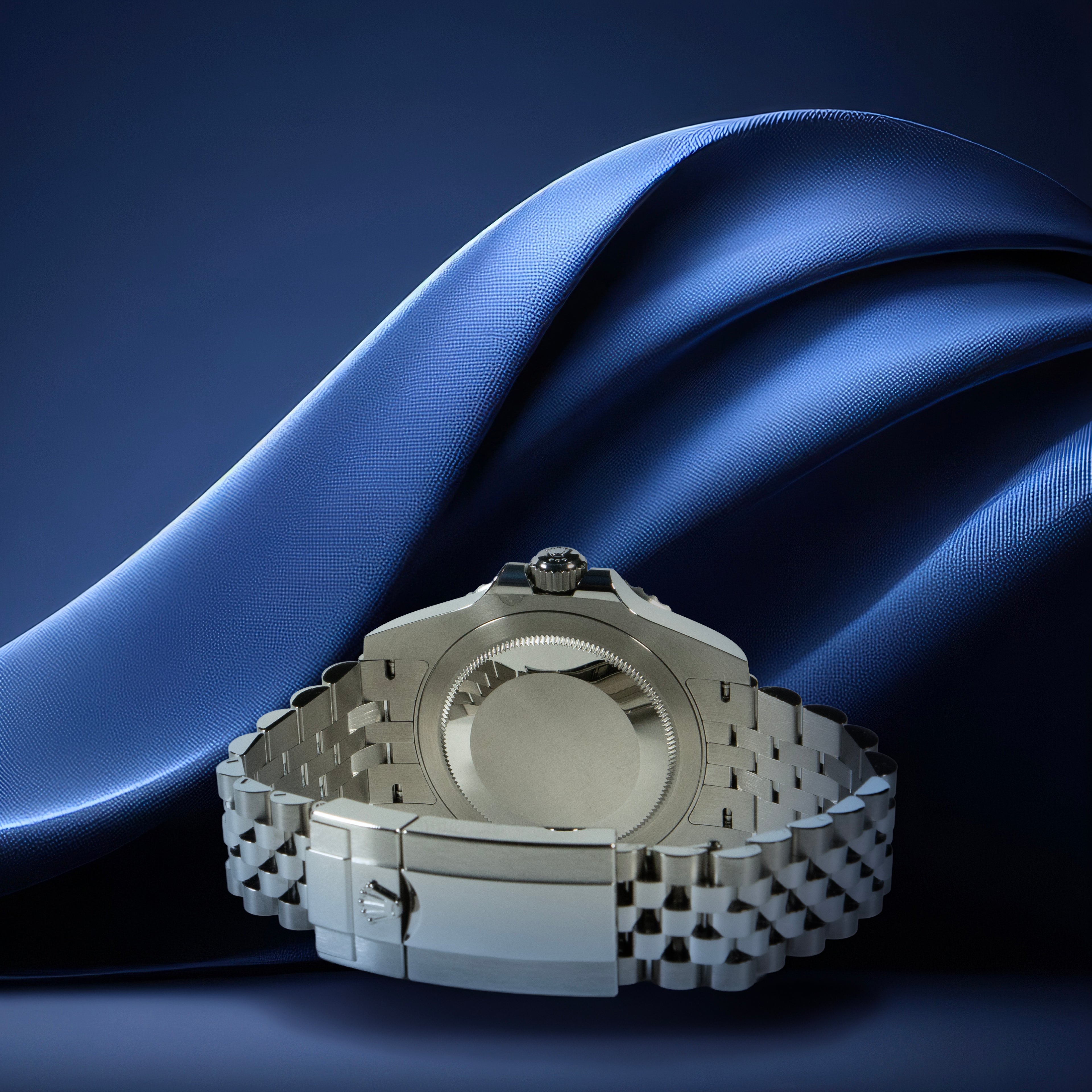 Silver watch on a blue fabric background